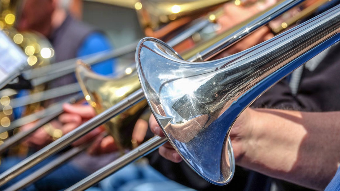 Closeup of a trombone player's instrument in a band lineup.